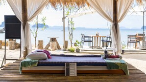A bed with a massage sign, a view of the sea, and outdoor seating. - Krabi Home Resort (Krabi)