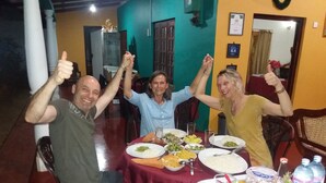 Un comedor con mesas dispuestas para una comida, sillas y un teléfono móvil sobre la mesa.