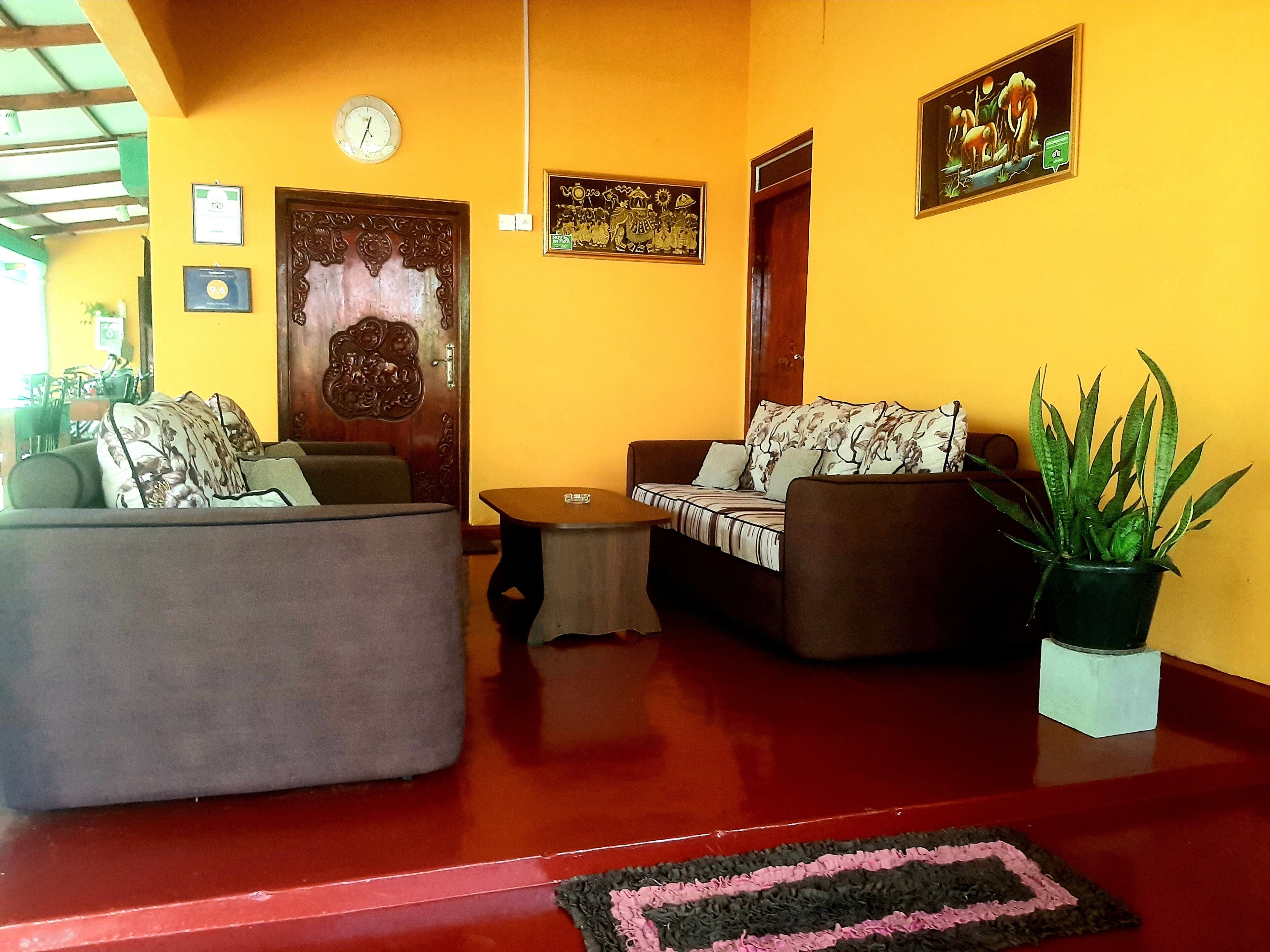 A living room with two sofas, a coffee table, and a potted plant.