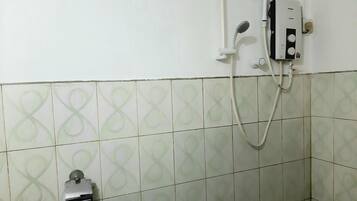 A bathroom with a shower, a toilet, and a wall-mounted heater.