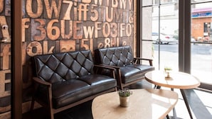A modern interior with a leather sofa and a round table, a wall with large letters, and a view of the street through large windows. - CHECK inn Express Taichung Yizhong (Taichung)