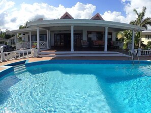 A pool area with a covered seating area and a clear blue pool. - Tumac Villa, 4BR by Jamaican Treasures (Duncans)