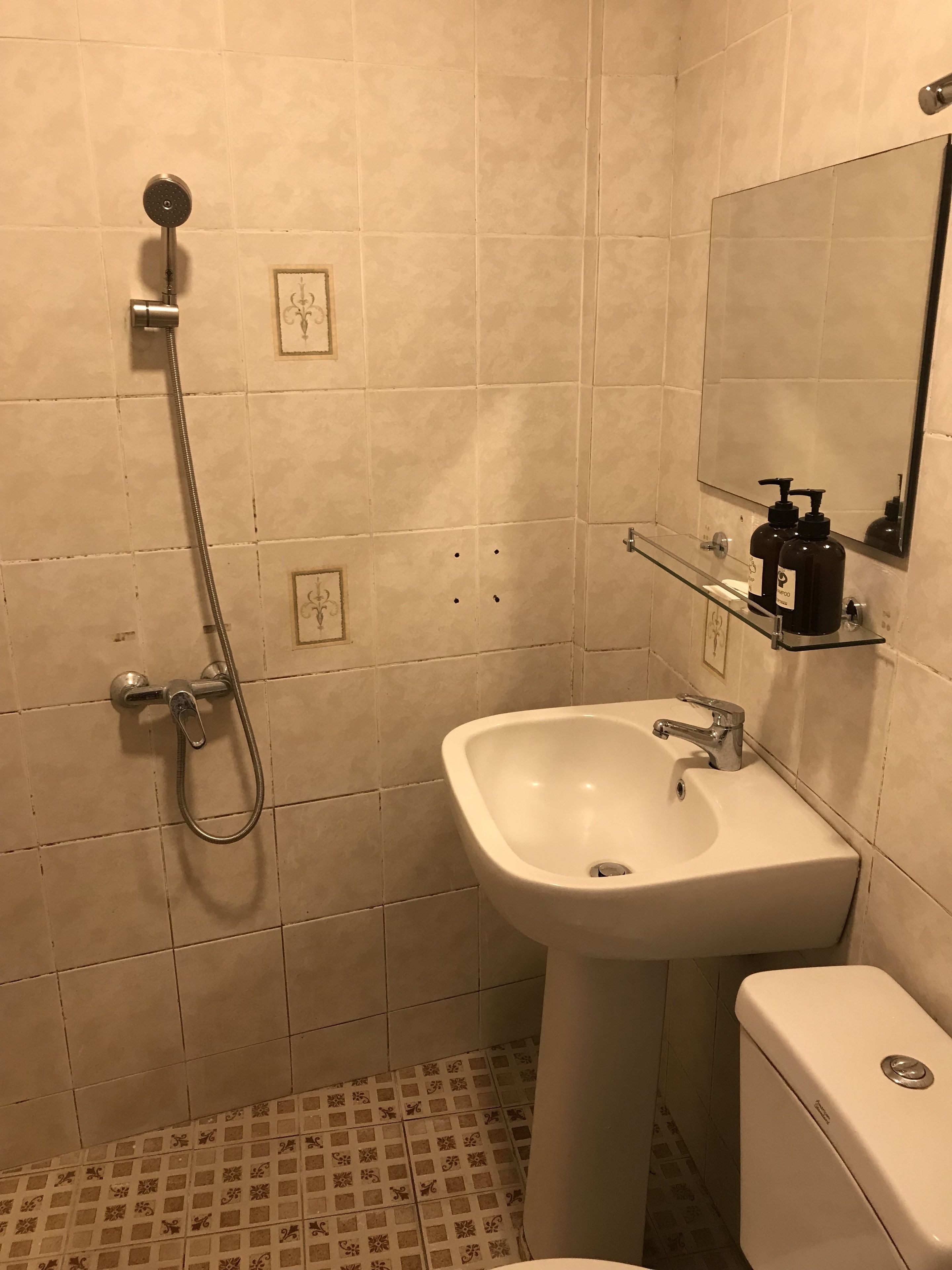 A bathroom with a shower, sink, and toilet.