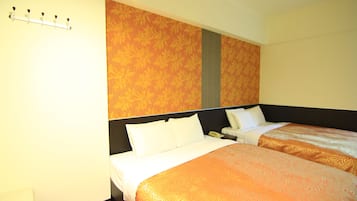 Habitación de hotel con dos camas, suelo de madera y pared con estampado.
