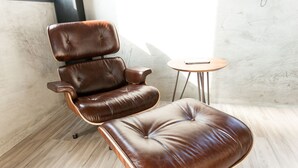 A brown leather recliner with a footrest and a small round table beside it. - Penghu Noah's Ark (Huxi)