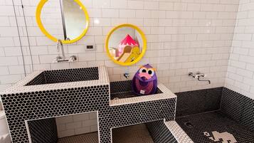 A bathroom with two sinks, each with a mirror, and a shower area with a hexagonal tile pattern.