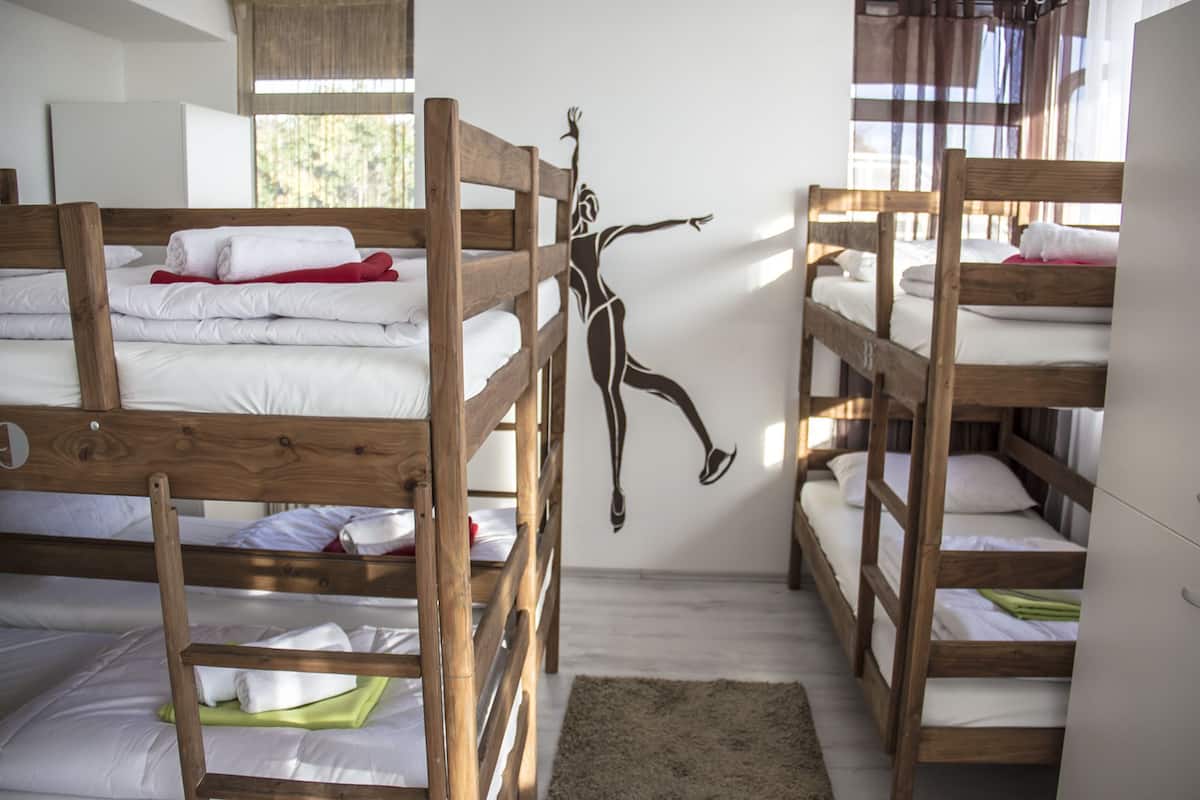 Una camera del dormitorio con letti a castello, una decorazione murale in legno e una finestra con tende.