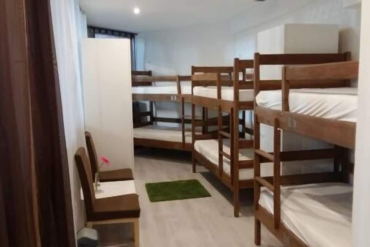Una camera in stile dormitorio con letti a castello, una scrivania e una sedia.