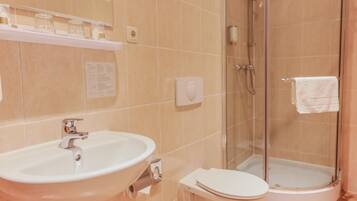 A bathroom with a sink, toilet, and glass-enclosed shower.
