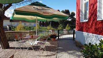 Et udendørs opholdsområde med en Staropramen parasol, et bord og stole.