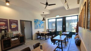 A modern cafe interior with wooden tables, a seating area, and a menu stand. - I See U Inn (Xincheng)
