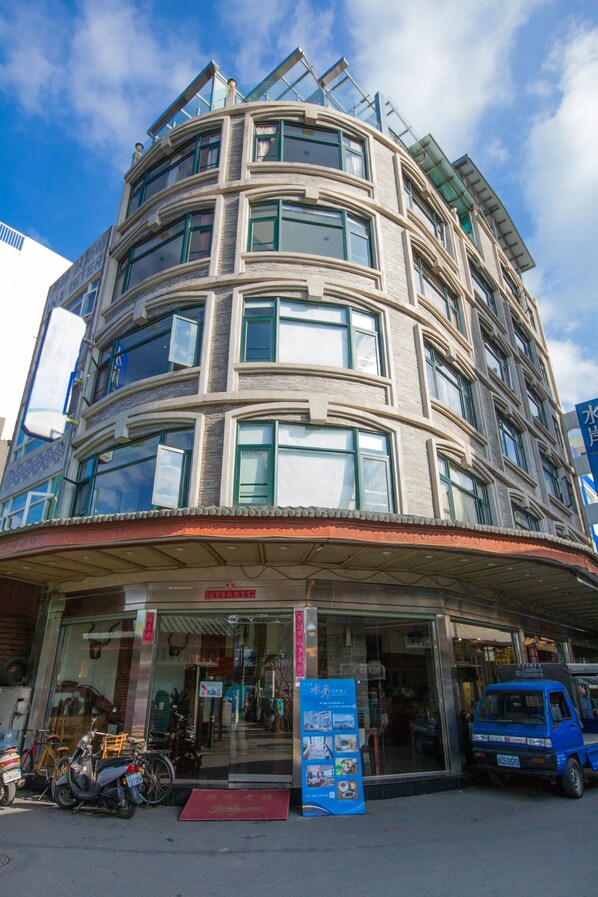 A multi-story building with a curved facade, large windows, and a covered entrance area. - Shuian Lakeside Hotel (Yuchi)