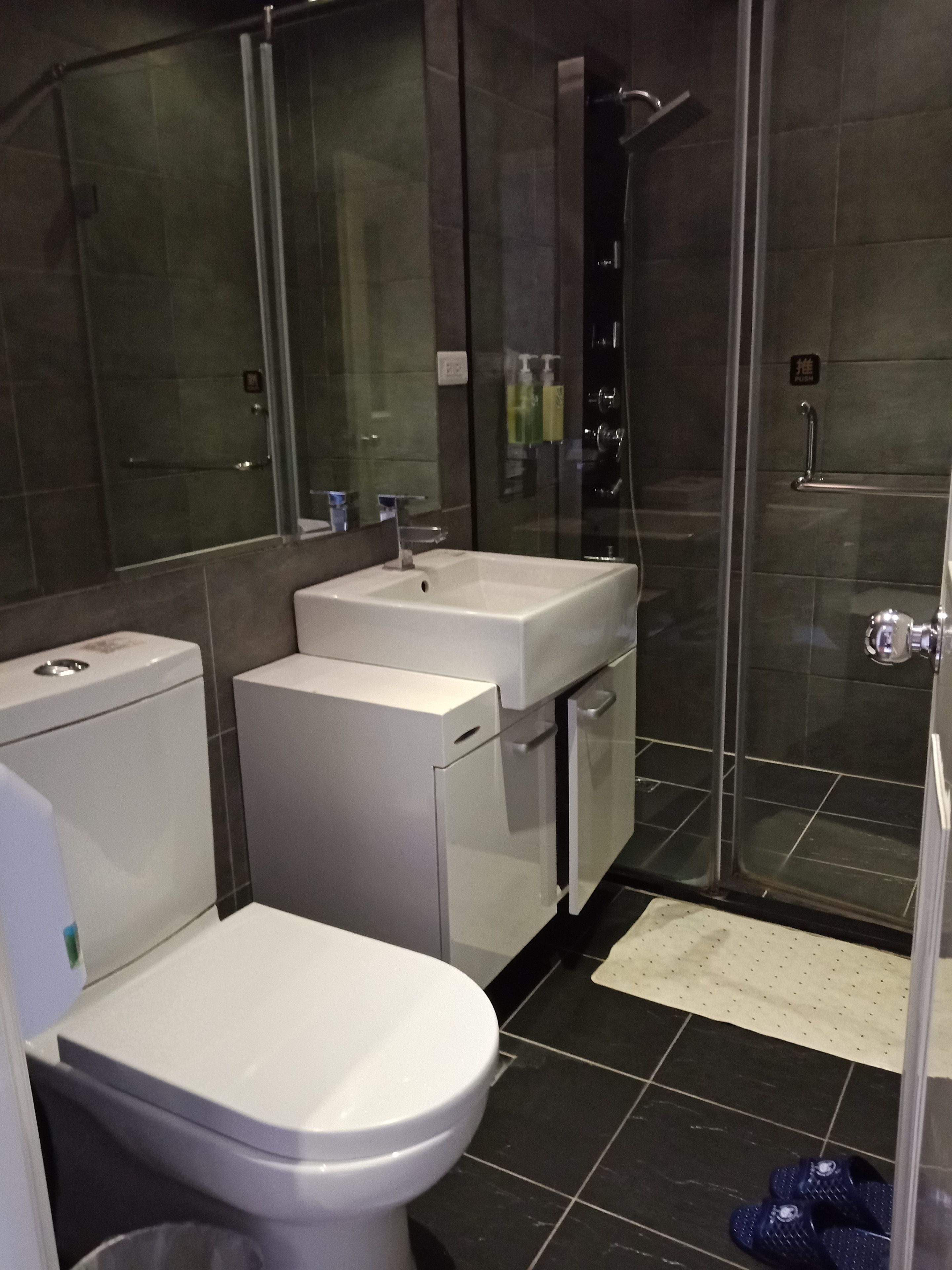 A modern bathroom with a toilet, sink, and shower area.