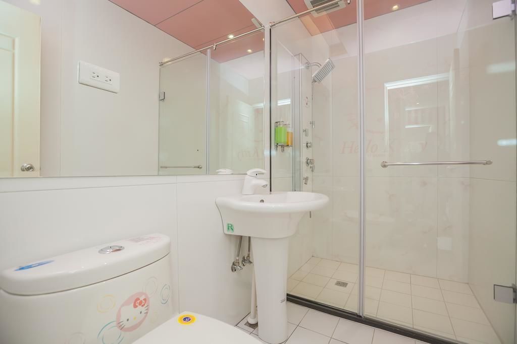 A bathroom with a toilet, a sink, and a glass-enclosed shower.