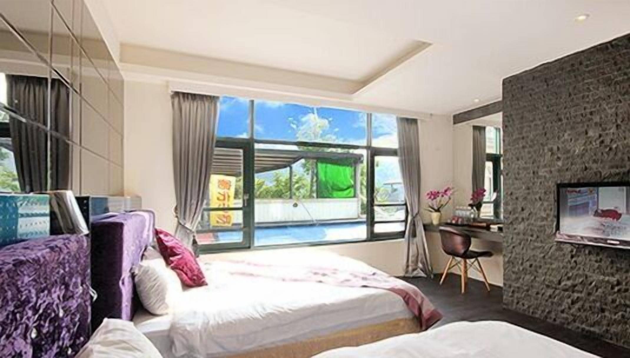 Une chambre d’hôtel moderne, dotée d’un grand lit, d’un bureau et d’une télévision.