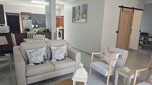 Un salon moderne avec un canapé gris, une table basse en bois et une lanterne blanche.