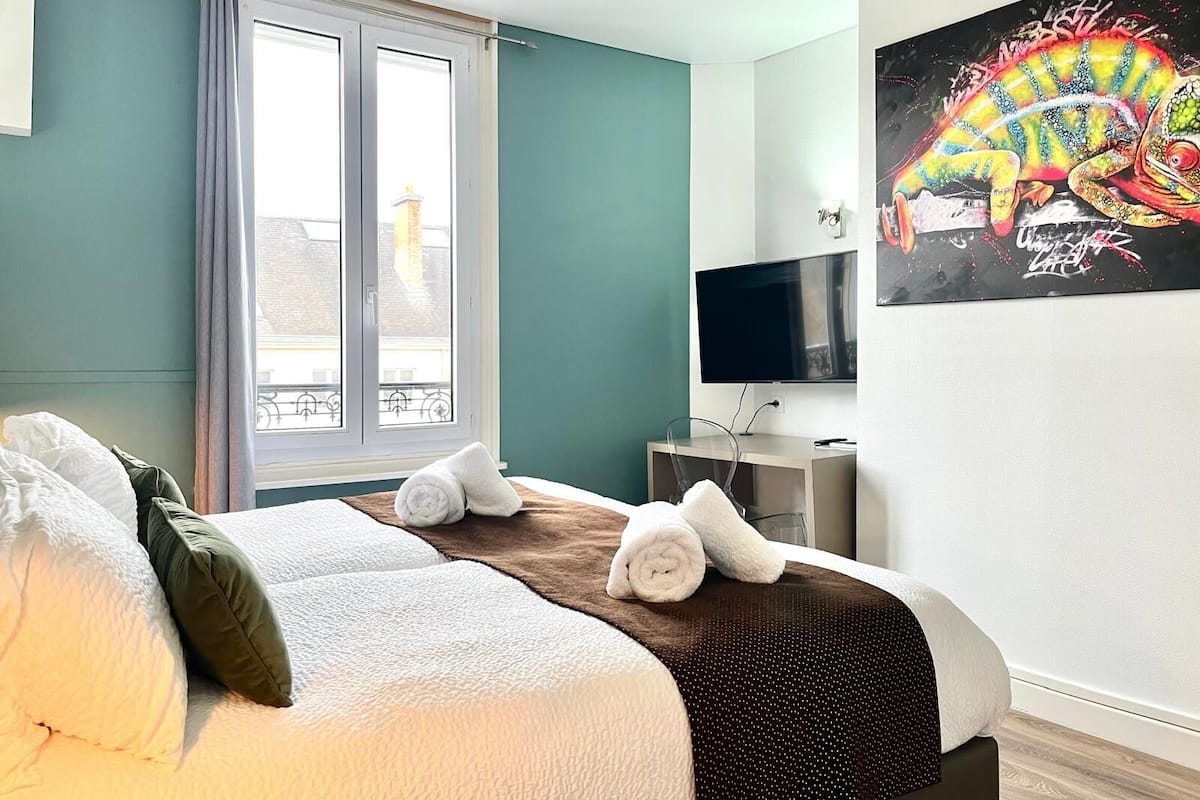 Ein Hotelzimmer mit Bett, Fernseher und einem Gemälde.