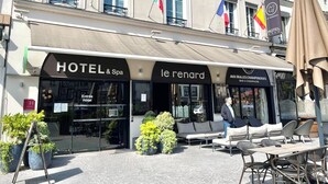 Fachada de hotel con un letrero que dice "HOTEL & Spa le renard" y un bar llamado "AUX BULLES CHAMPAGNES".