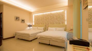 A hotel room with two beds, a bedside table with a lamp, a teddy bear, and a wall with a decorative pattern.