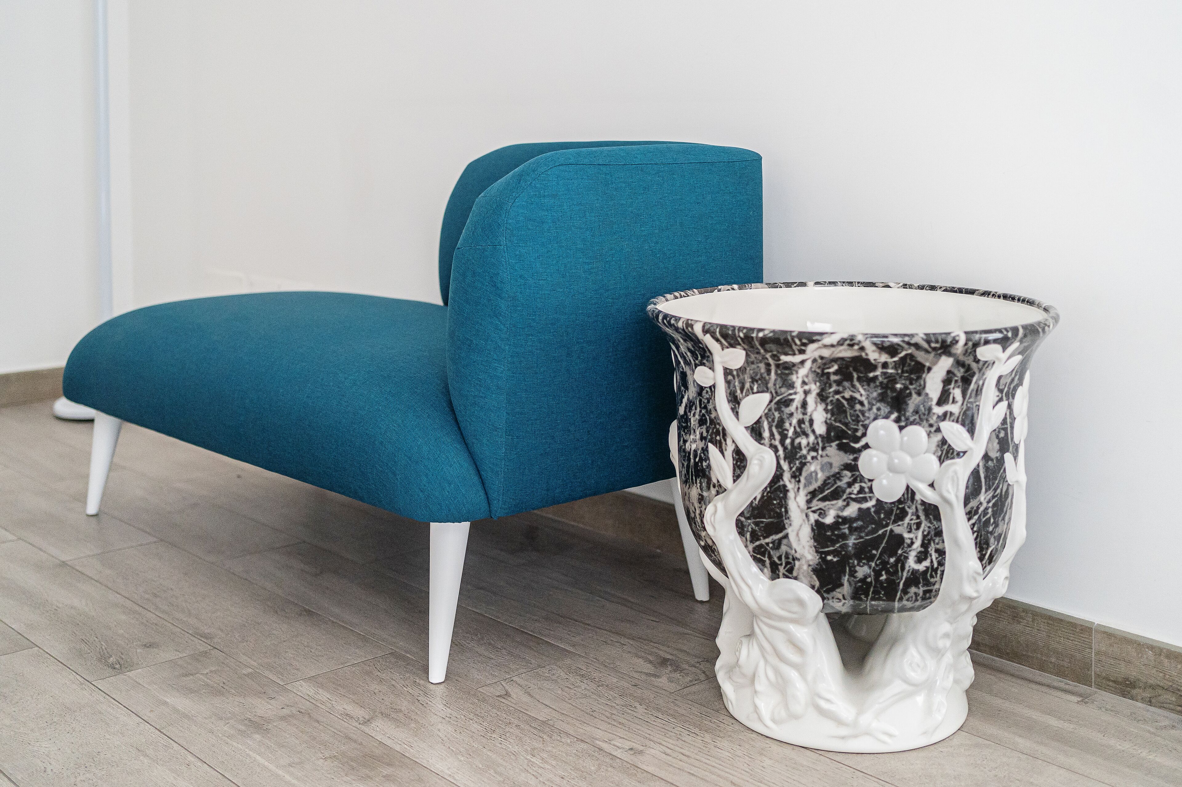 Un sillón color turquesa y una mesita auxiliar con diseño de mármol.