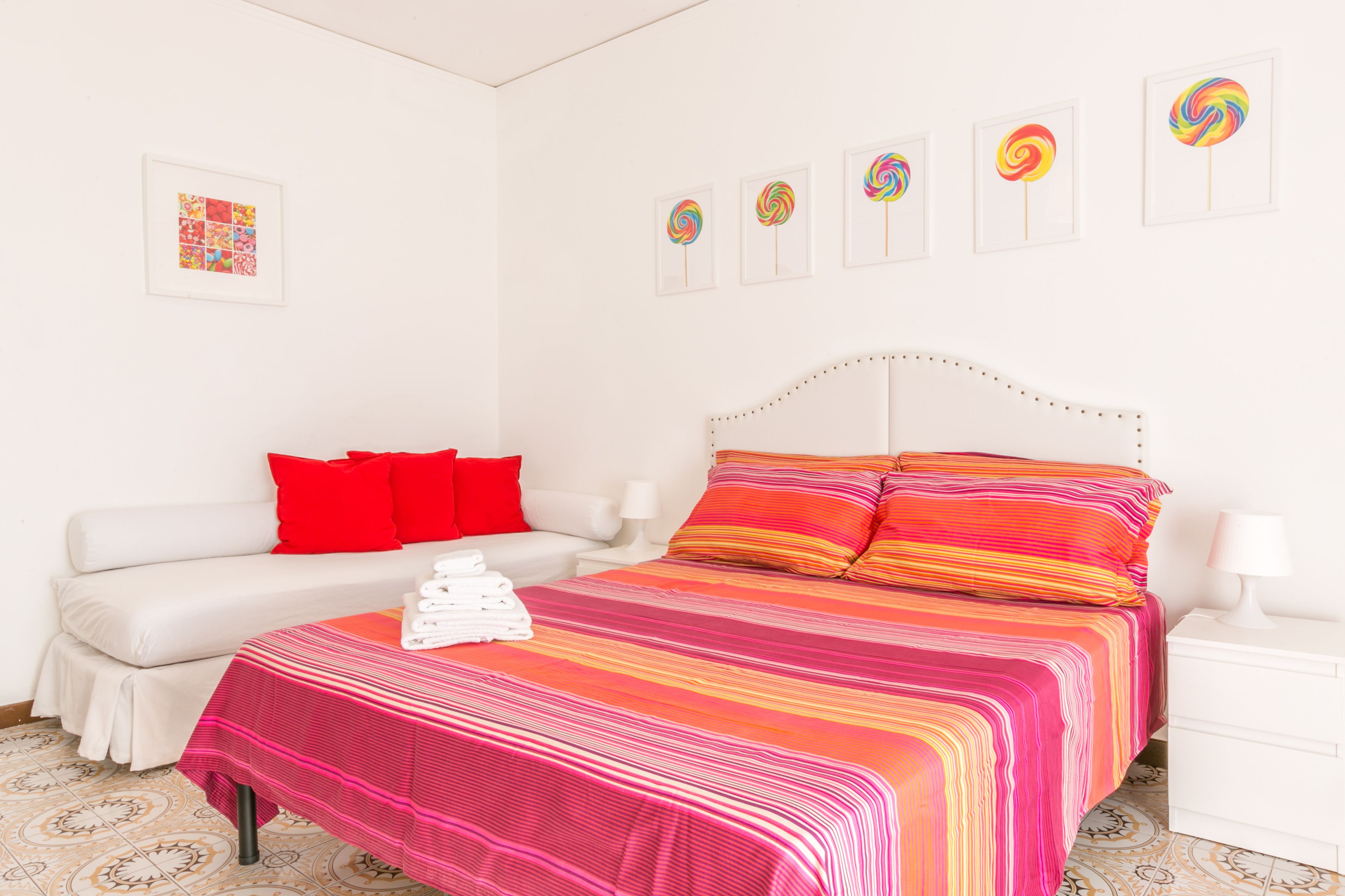 Un dormitorio con cama, sofá y mesita de noche.