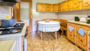 A kitchen with wooden cabinets, a stove, a round table with a lace tablecloth, and a tiled backsplash. - Sorrento 3 bedrooms Sunny Apt with terrace & view (Sorrento)