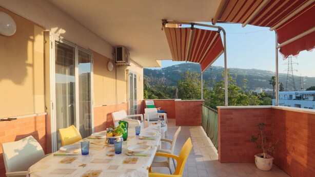 A covered outdoor dining area with a table set for two, chairs, and a potted plant. - Sorrento 3 bedrooms Sunny Apt with terrace & view (Sorrento)