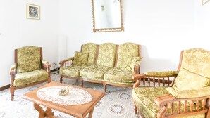 A room with a green patterned sofa, two armchairs, a wooden coffee table, and a large mirror on the wall. - Sorrento 3 bedrooms Sunny Apt with terrace & view (Sorrento)
