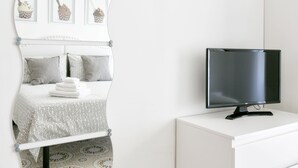 A neatly arranged bedroom with a bed, pillows, a TV on a white dresser, and framed pictures on the wall. - Sorrento 3 bedrooms Sunny Apt with terrace & view (Sorrento)