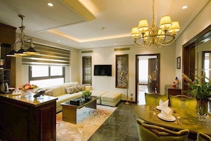 A modern living room with a sofa, coffee table, and dining area.
