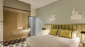 Una habitación de hotel moderna con una cama grande, cabina de ducha de vidrio y decoración artística en la pared.