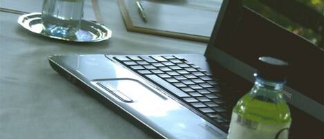 A laptop on a table with water bottles and a pen.