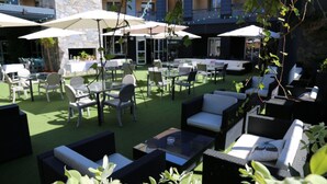 An outdoor patio area with seating arrangements and umbrellas. - Cors Hotel (Biguglia)
