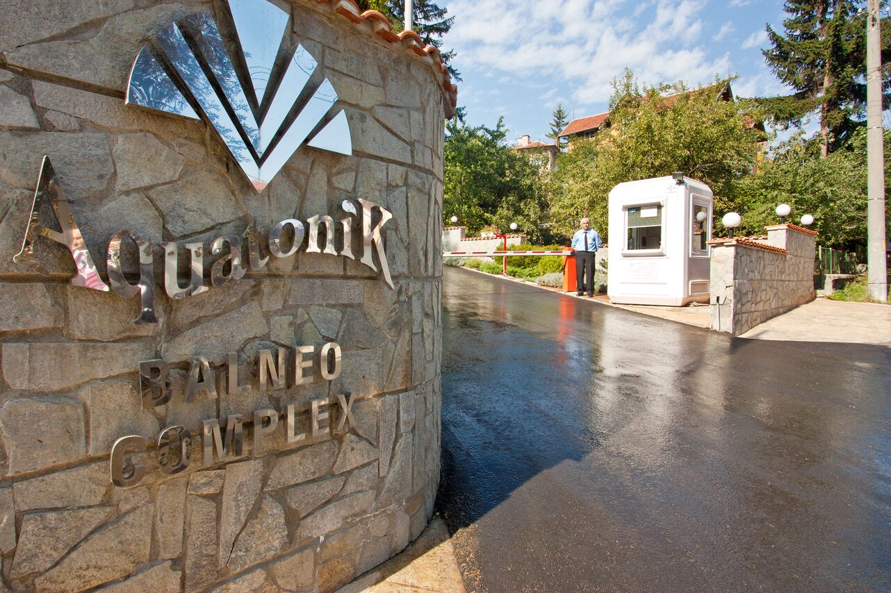 Un letrero de piedra con el nombre 'Aquonik' y 'Complejo Balneo' que indica una zona de hotel o resort.