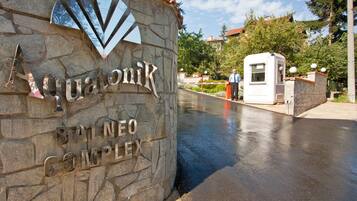 Un letrero de piedra con el nombre 'Aquonik' y 'Complejo Balneo' que indica una zona de hotel o resort.