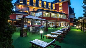 Een hotel met meerdere balkons, buiten zitplaatsen en een goed verlicht terras.