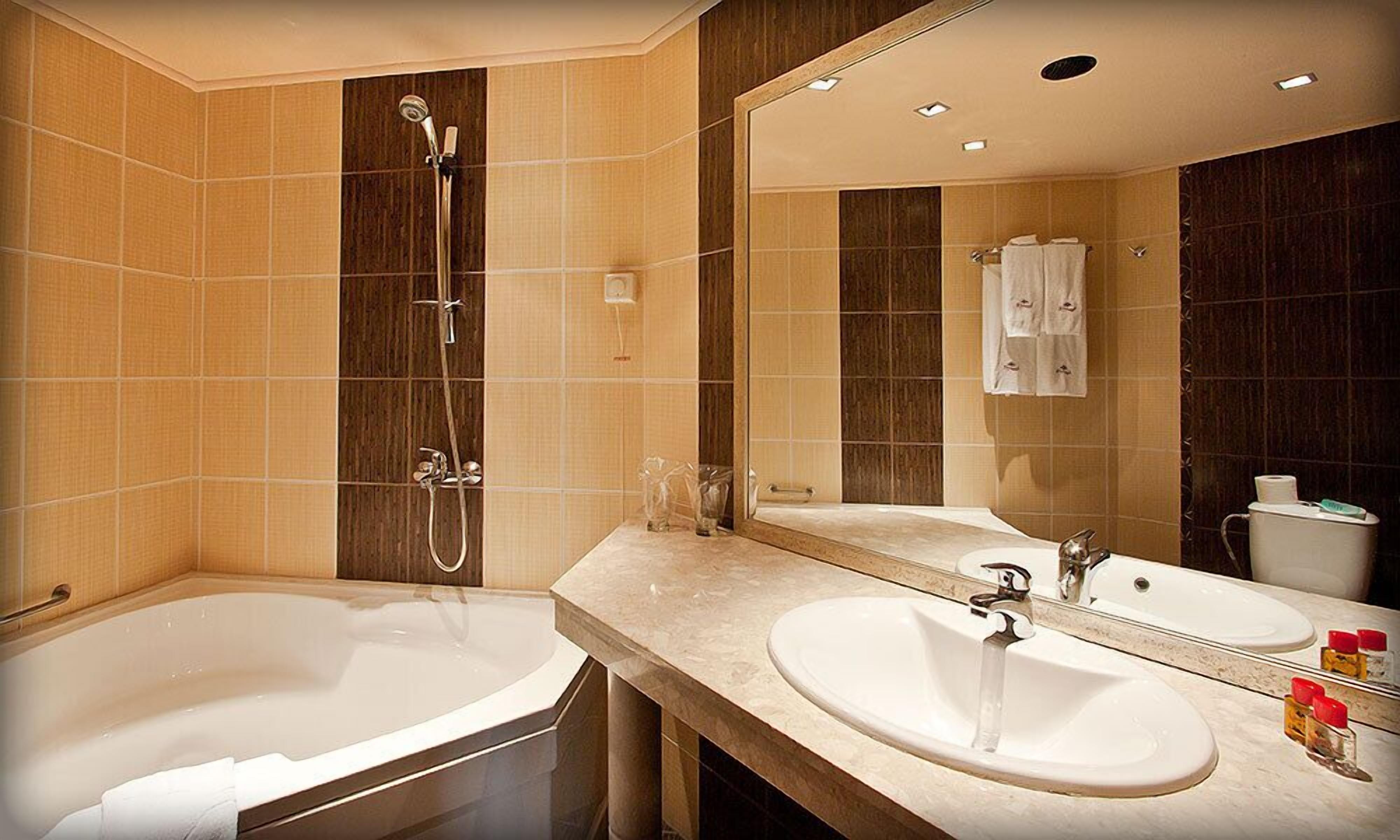 A modern bathroom with a bathtub, a shower, and a sink.