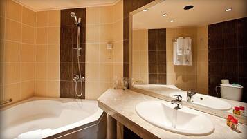 A modern bathroom with a bathtub, a shower, and a sink.