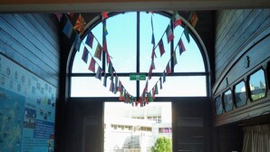 Une porte ornée de drapeaux, une carte et une vue sur l’extérieur.