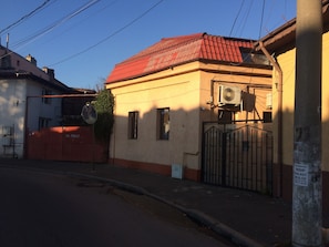 A building with a red roof, a gated entrance, and an air conditioning unit mounted on the wall. - Bucharest Center Villa (Bucharest)