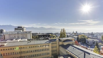 Ein mehrgeschossiges Gebäude mit flachem Dach und einem Parkplatz davor.