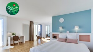 A modern hotel room with a large bed, a desk, a chair, and a small table. - Hôtel des Patients (Lausanne)