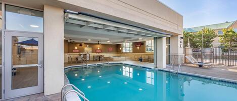 A swimming pool with a sunshade, a covered seating area, and a no diving sign.