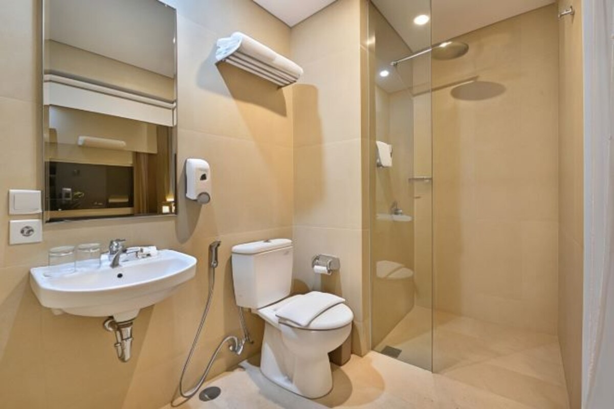 A modern bathroom with a sink, toilet, and glass-enclosed shower.