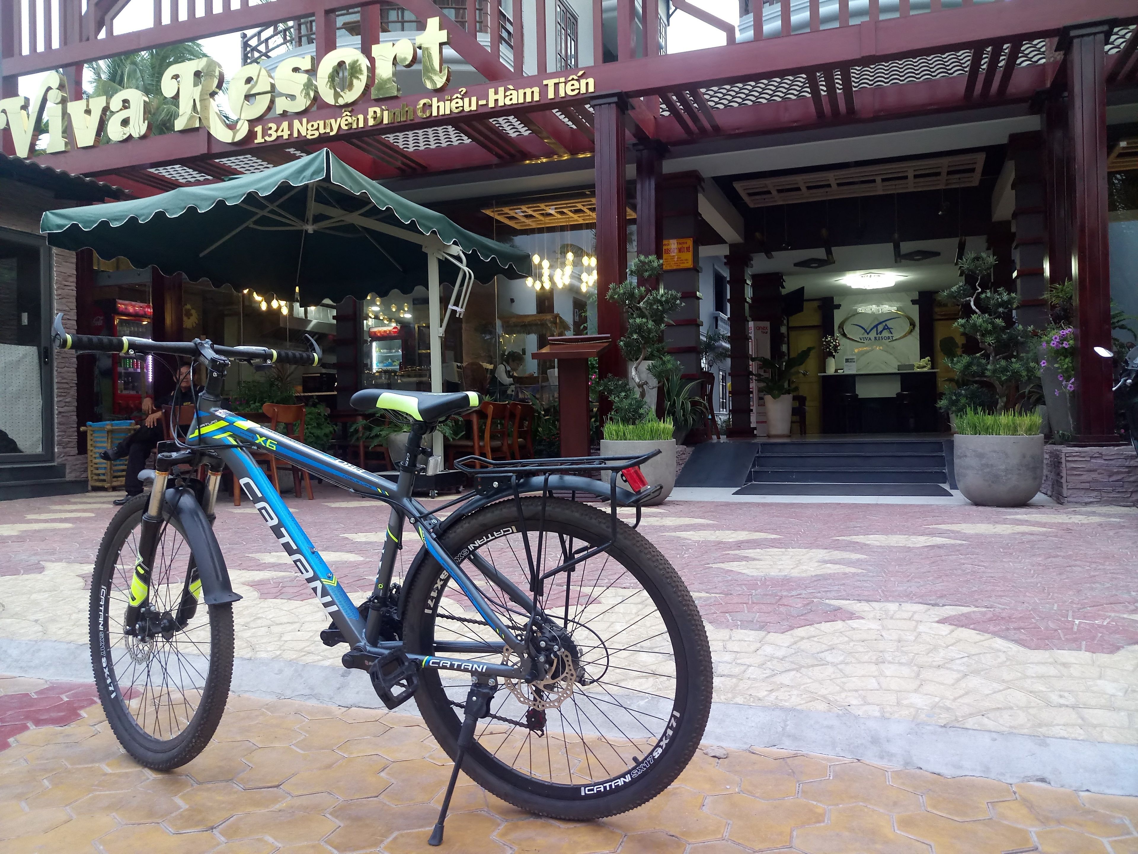Ein Fahrrad vor dem Viva Resort, einem Gebäude mit einem Schild, das Name und Adresse angibt.