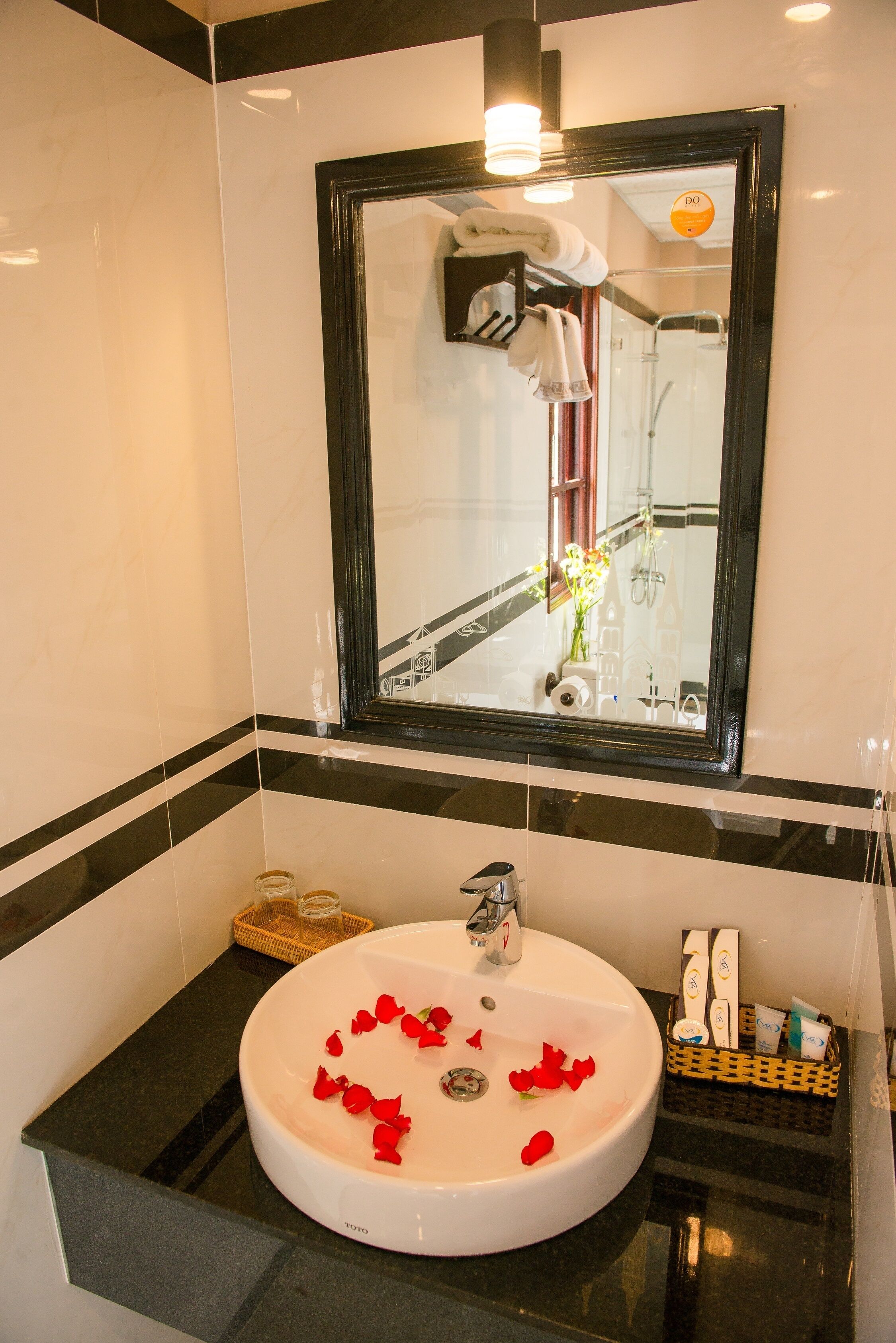 A bathroom with a round sink, a mirror, and a towel rack.