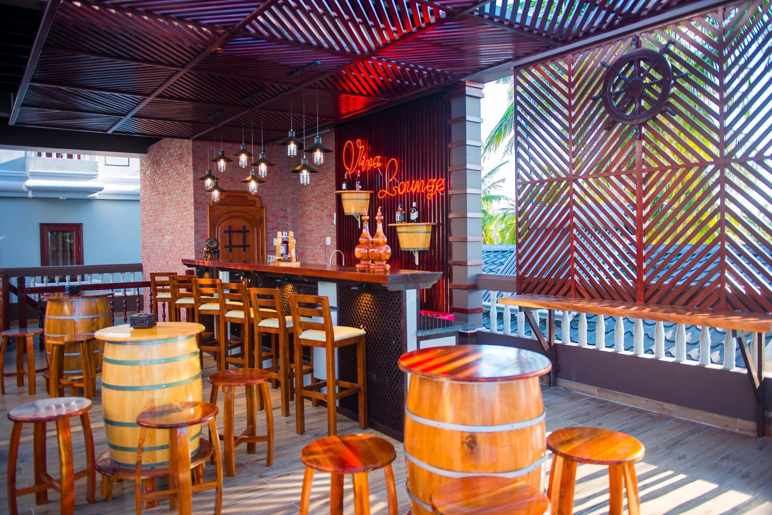 A bar area with wooden furniture, a neon sign, and a patterned wall.
