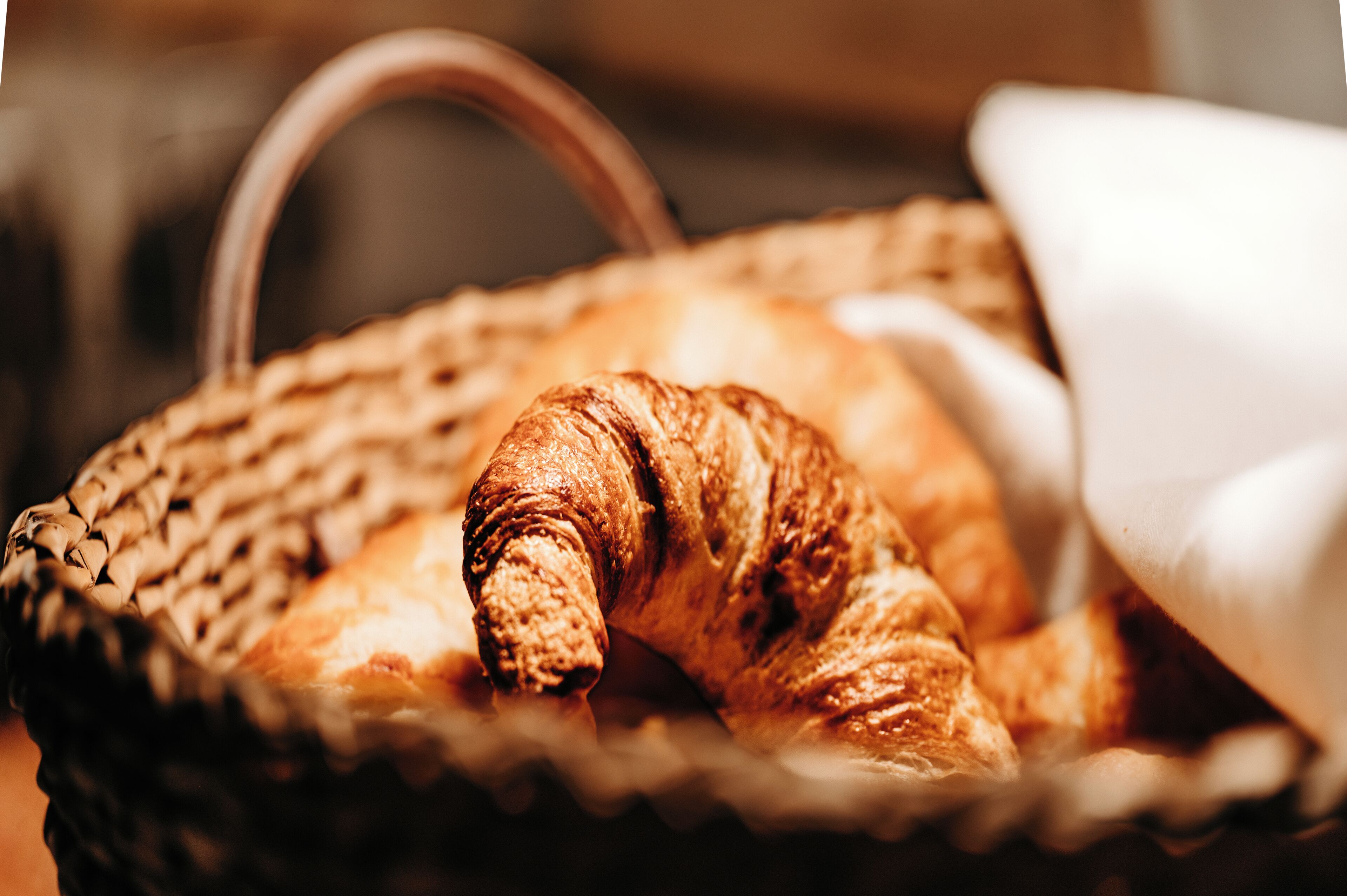 Een mandje met een croissant en een gebakje.