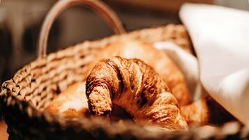 Een mandje met een croissant en een gebakje.