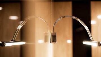 A modern bathroom with two chrome faucets and a central control panel.